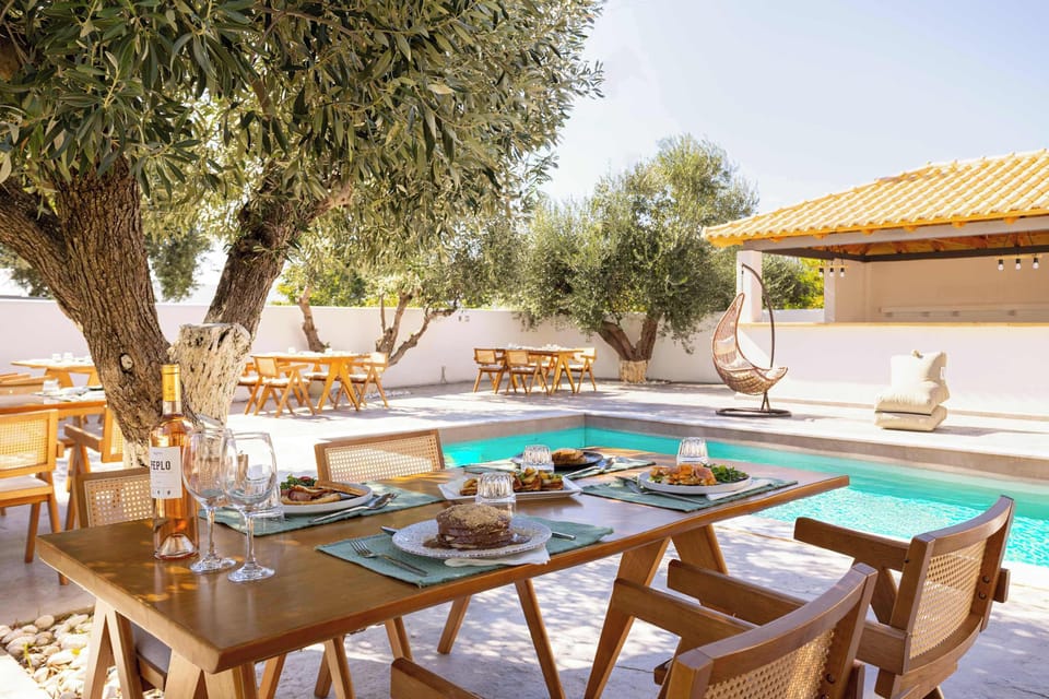Shared Pool Area with Olive Trees and Sun Loungers
Relaxing communal pool surrounded by shade, dining tables, and rustic stone details.