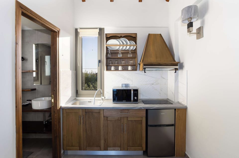 Fully Equipped Kitchenette with Wooden Cabinets
Compact cooking space with oven, fridge, and practical layout.
