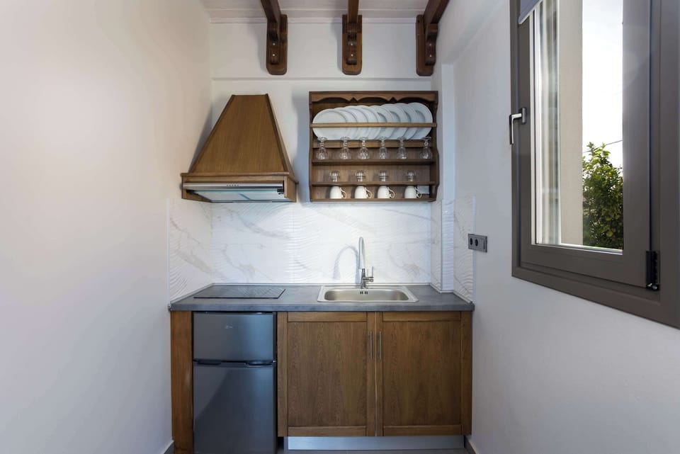 Kitchenette with Wooden Cabinets and Complete Appliances
Functional cooking space with stove, microwave, open shelving, and tile accents.