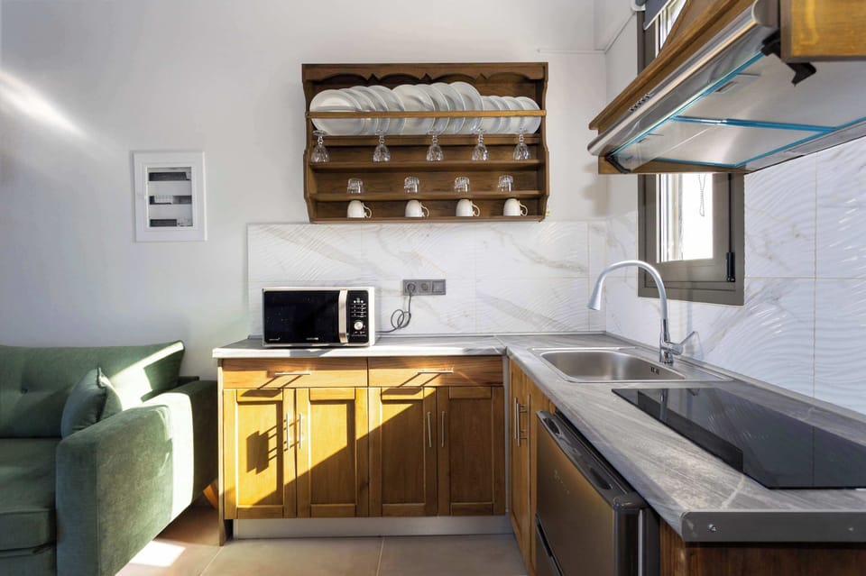Fully Equipped Kitchenette with Wooden Cabinetry
Practical kitchen space with stove, fridge, and overhead storage.