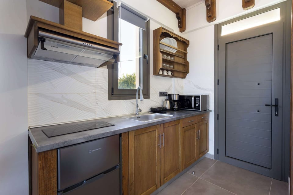Fully Equipped Kitchenette with Wooden Cabinets and Dining Area
Practical kitchenette with oven, fridge, and workspace.