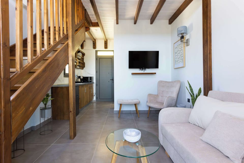 Living Area with TV, Sofa, and Wooden Ceiling Beams
Modern interior featuring high ceilings and warm tones.