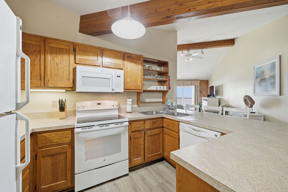 A spacious kitchen connects seamlessly to the living area, where coastal  views create a bright and inviting atmosphere for relaxation.