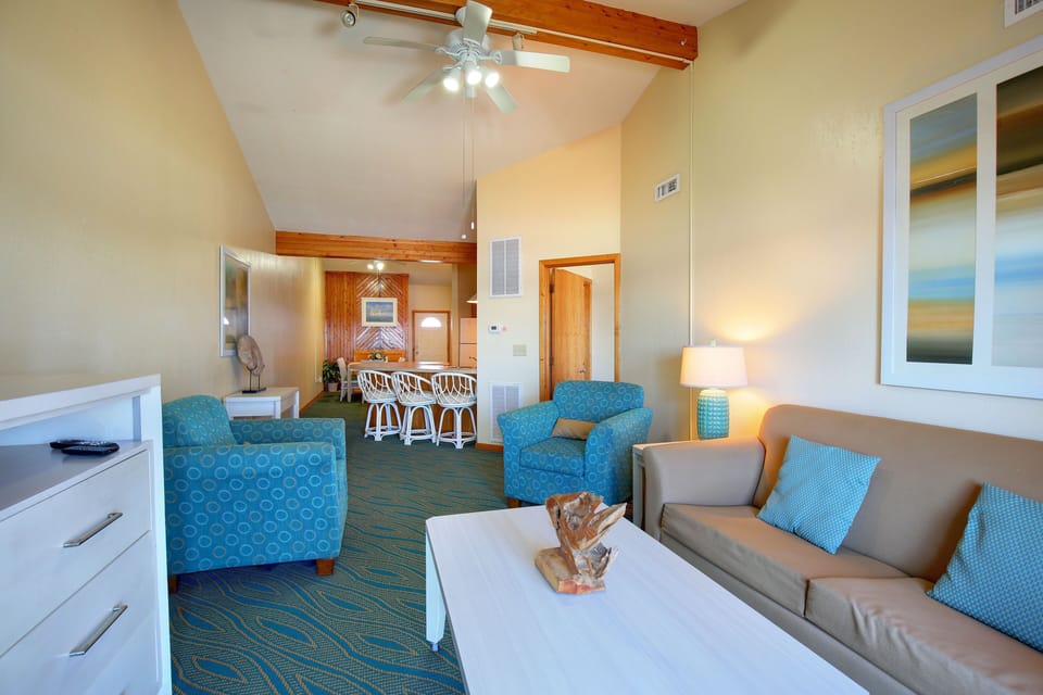 The inviting living area features vibrant decor and plenty of seating, making it ideal for relaxation after a day at the beach.