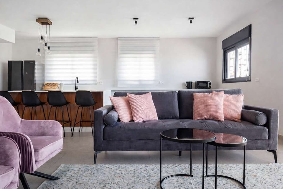 Unwind in the airy living room where comfortable seating meets easy access to balcony breezes.