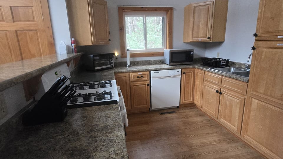 Spacious kitchen with all essentials, cookware, pans, slow cooker, indoor grill, air fryer, and utensils