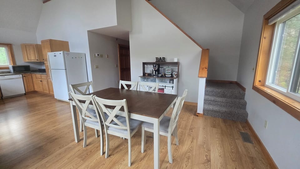 Dining area with a table for six and a combined bar and coffee station.