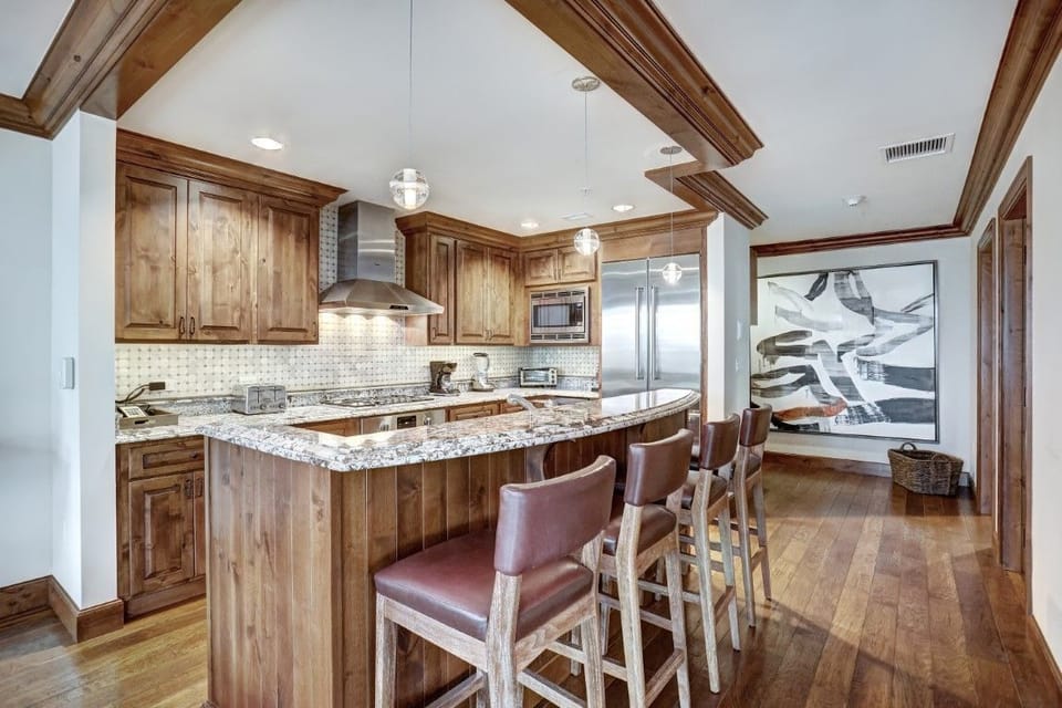 Stylish bar seating in the kitchen area complements the gourmet space, enhancing the open concept living and entertaining experience.