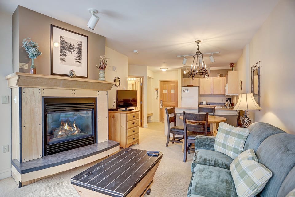 Relax in the inviting living area featuring a cozy fireplace, plush seating, and an open layout that connects to the kitchen.