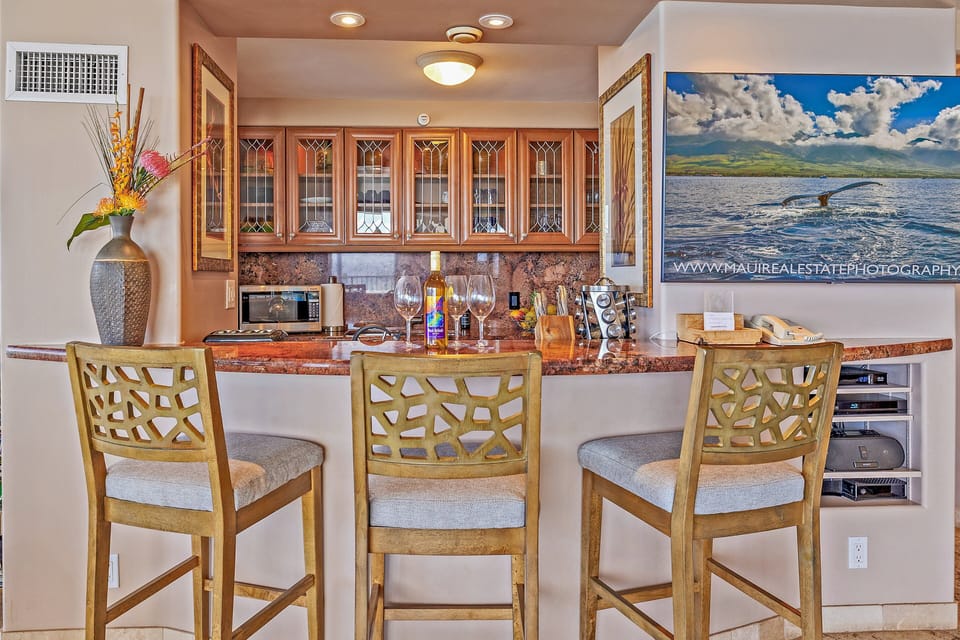 • 	Kitchen bar with high chairs and glass cabinets, the soft glow of pendant lights and the aroma of coffee mingling with sea breezes.