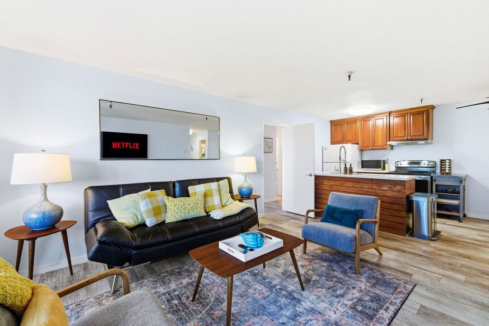 The spacious open layout seamlessly connects the living room, dining area, and kitchen, creating the perfect gathering space for family and friends after a day at the beach.