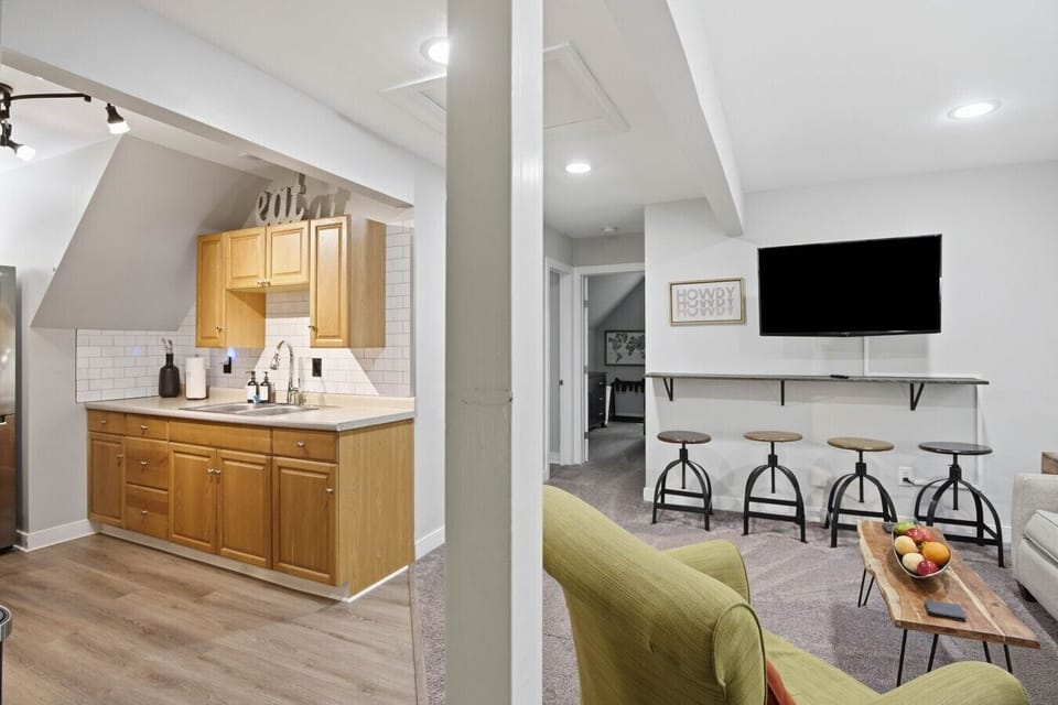 A bright and inviting upstairs living room with cozy seating, warm lighting, and a flat‑screen Roku TV. Enjoy “dinner and a show” at the floating bar, or unwind on the comfy sofa bed just steps from the full kitchen.