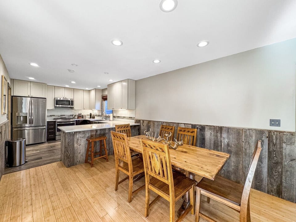 Dining area opening to the kitchen, everyone`s in the same space whether cooking, eating, or just hanging out. Island seating, good counter space, flow that keeps families connected.