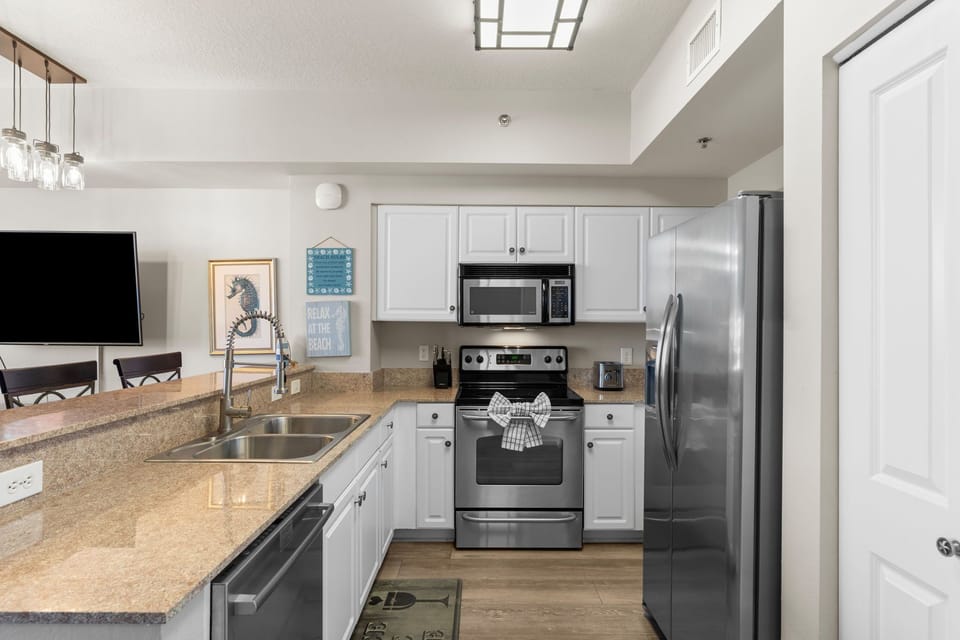 Bright, fully equipped kitchen with ample counter space for prepping meals after a day at the beach.