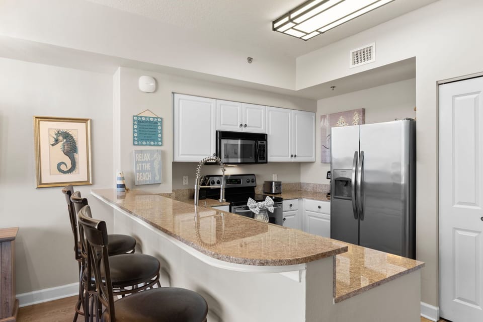 Bright, fully equipped kitchen with ample counter space for prepping meals after a day at the beach.