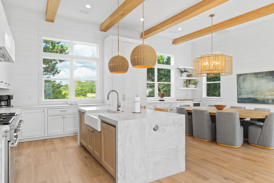 A chef's dream kitchen with high-end appliances, a large center island for prep and gathering, and a chic, dedicated dining area.