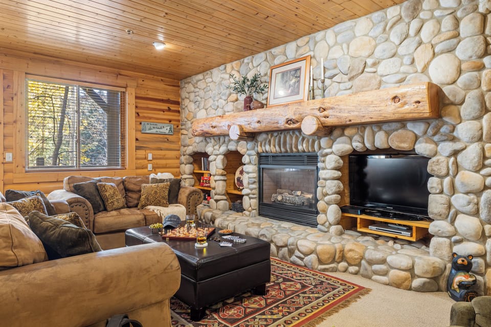 Cozy living room with TV, comfortable sofa, and fireplace.