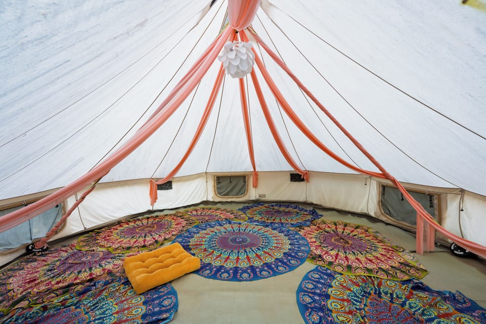 Relax inside this spacious, boho-style tent set in a serene natural landscape.