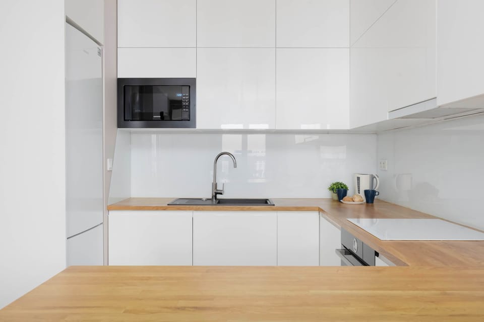 Bright, fully equipped kitchen with essential appliances and ample workspace.