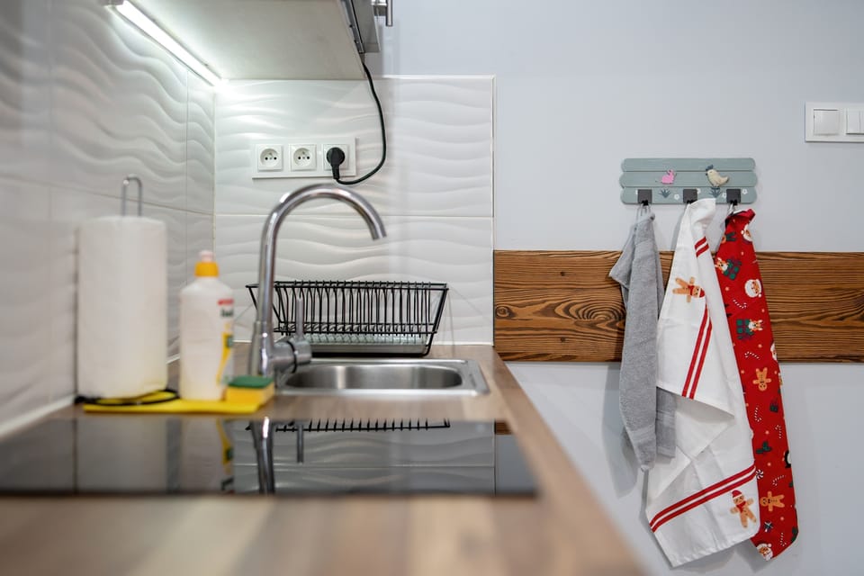 A fully equipped kitchen with plenty of counter space and modern appliances. The design is sleek with light-colored wood and white cabinets.