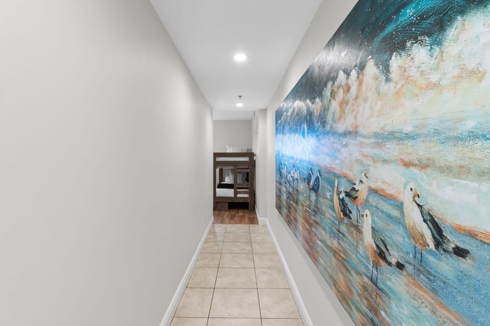 A bright, airy layout and beach-themed artwork set the tone for a relaxing stay, while thoughtful details like a bench for kicking off flip-flops and hooks for beach bags and towels make it as practical as it is picturesque.
