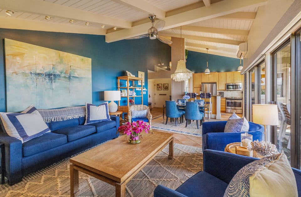 Sofas and art frame vaulted ceilings, dining spaces flowing into the design.