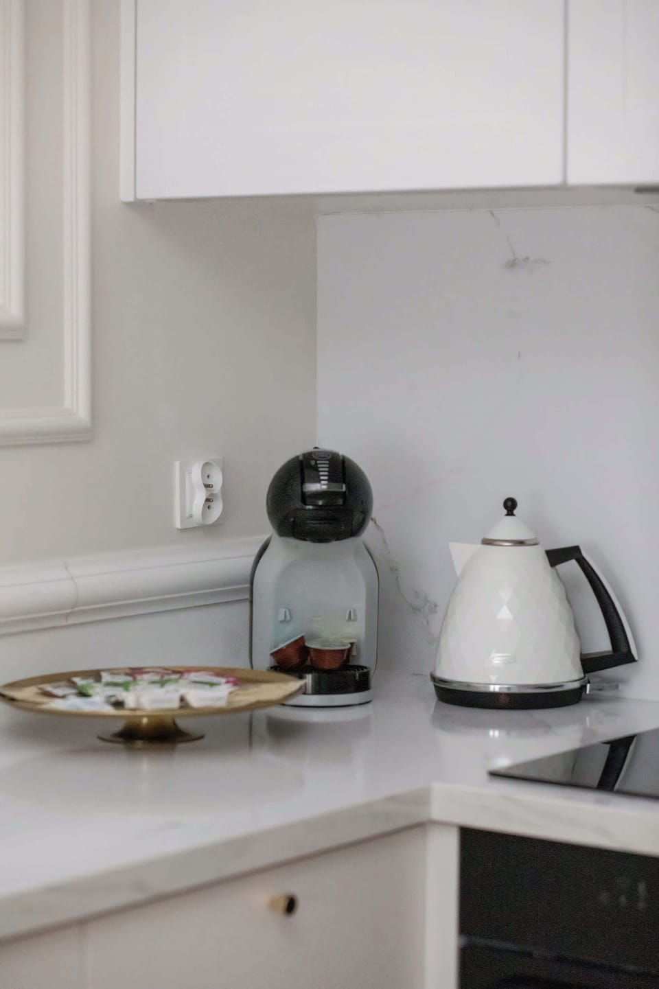 There is an electric kettle and a coffee machine on the kitchen counter.