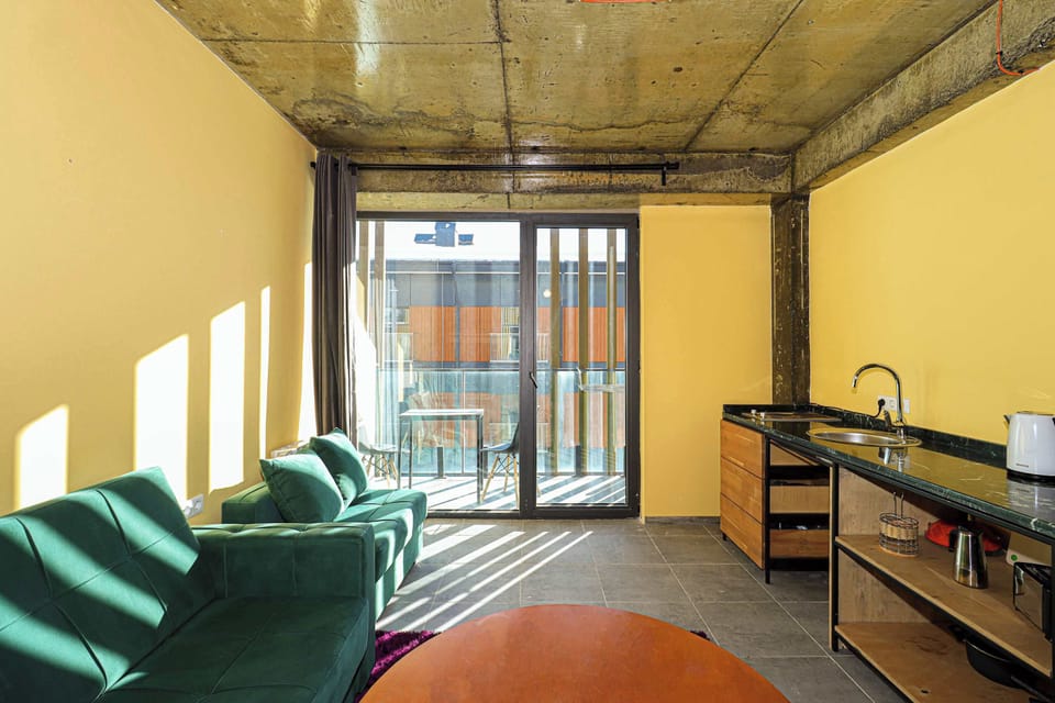 Expansive windows bathe the interior in sunlight, revealing an awe-inspiring view of Gudauri’s peaks.