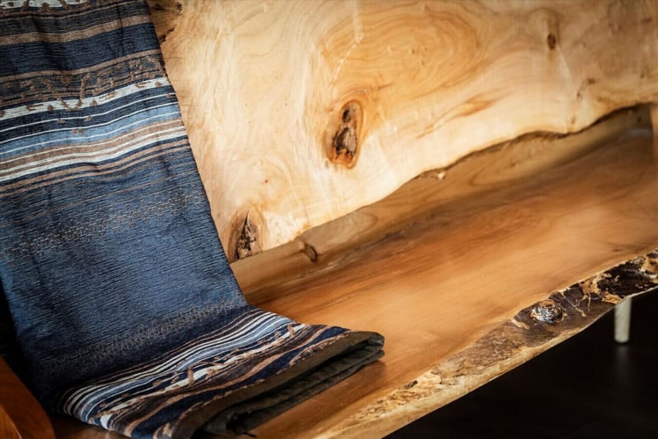 A beautiful blend of rustic charm and handmade craftsmanship—this live-edge bench and woven throw invite you to slow down and stay awhile.