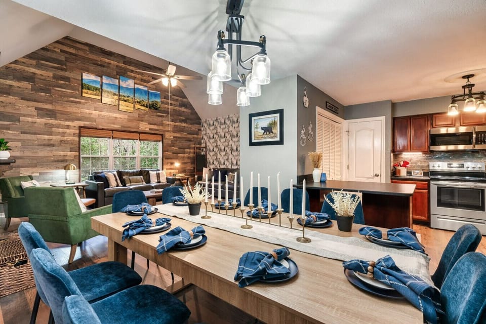 Gather around the large farmhouse-style table for a meal together or game night. The open layout blends into the warm kitchen and rustic living area, making this the heart of the cabin.