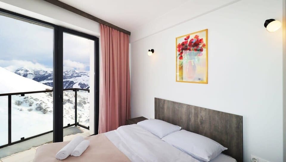 The bedroom is separated and has access to a balcony, with plush pillows and a comfortable mattress.