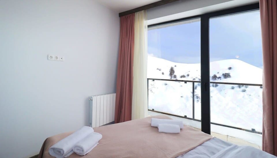 Wake up to the stunning view of the snow-covered Gudauri mountains.