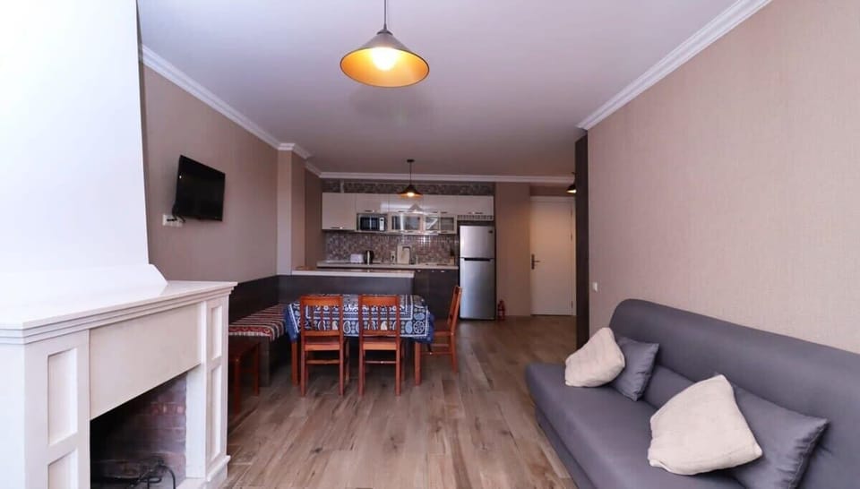 The spacious living area is perfect for groups, offering plenty of room for hanging out, playing games, dining, cooking, and relaxing by the cozy fireplace