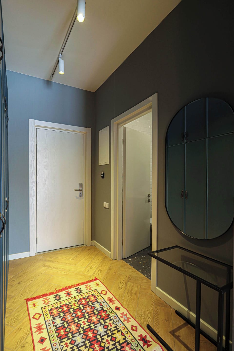 A warm and inviting entrance featuring a bright, colorful carpet and a chic mirror!