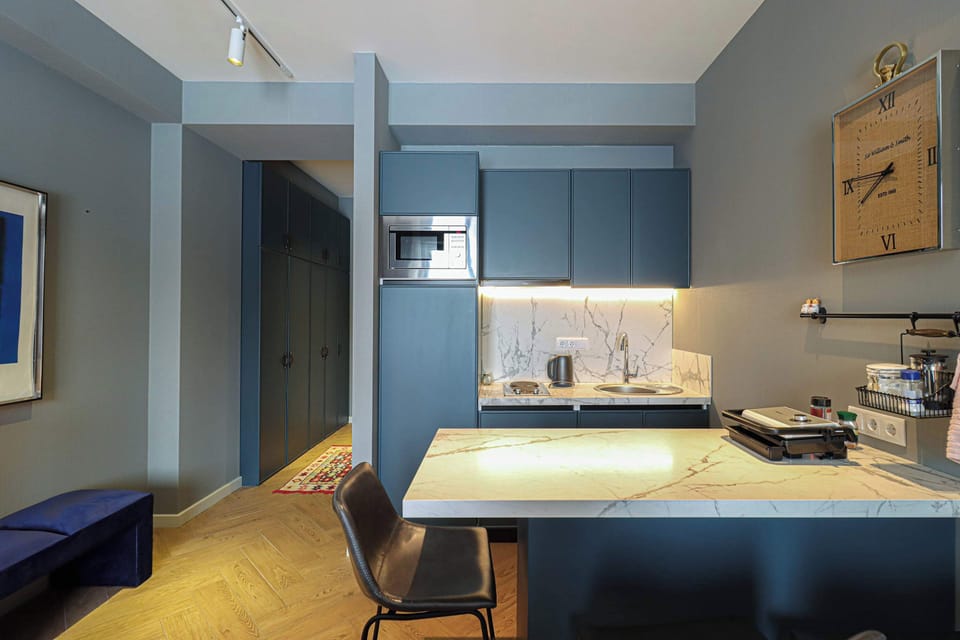 The kitchen is fully equipped with a fridge, stove, microwave, cookware, dishes, and essential cooking supplies. 