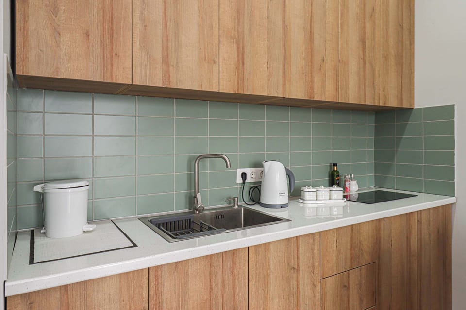 The kitchen has a stove, kettle, cookware, dishes, and essential cooking supplies. 