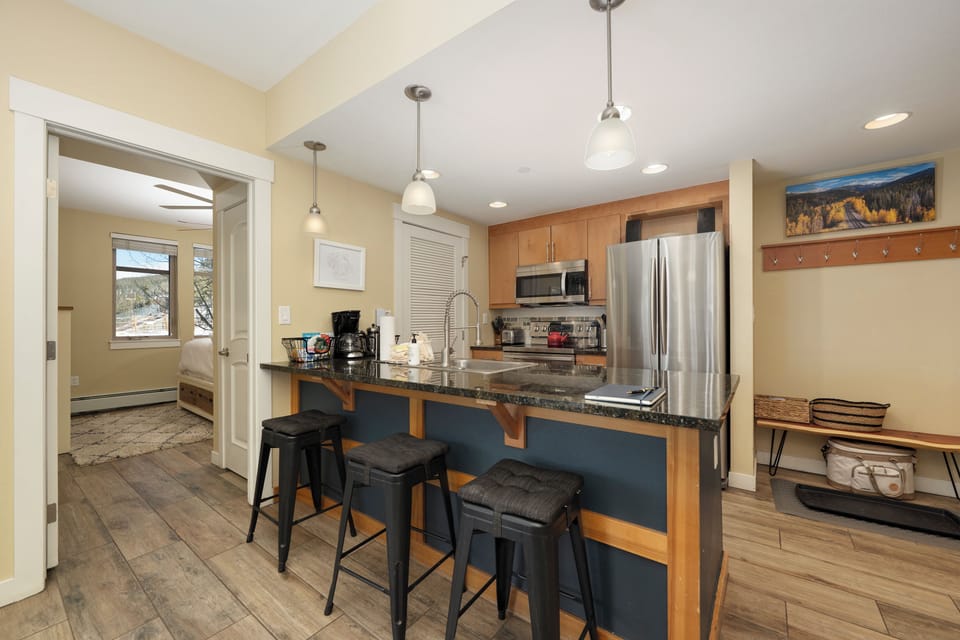 Your fully equipped kitchen features granite countertops, stainless steel appliances, and a breakfast bar where you can enjoy morning coffee.