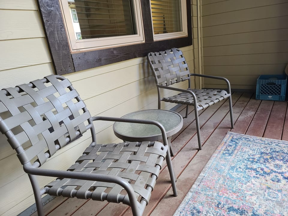 Step onto your private covered patio and settle into stylish woven chairs where you can unwind with morning coffee or evening conversations.