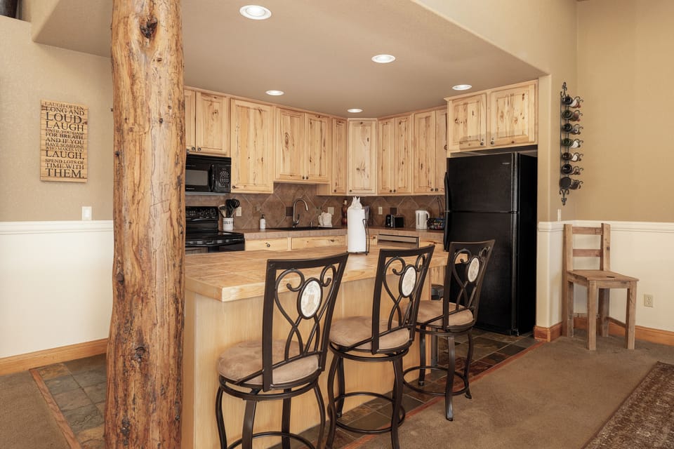Your rustic kitchen features warm pine cabinets, granite counters, and a breakfast bar where you'll sip coffee while enjoying the cabin charm.