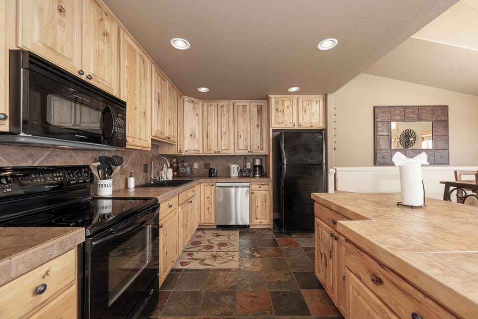 Prepare delicious meals in this fully equipped kitchen featuring rustic wood cabinets and modern appliances for your culinary adventures.