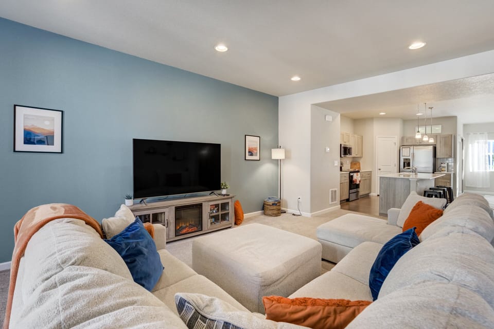 Spacious family room with the comfiest sectional, large Smart TV, and electric fireplace.