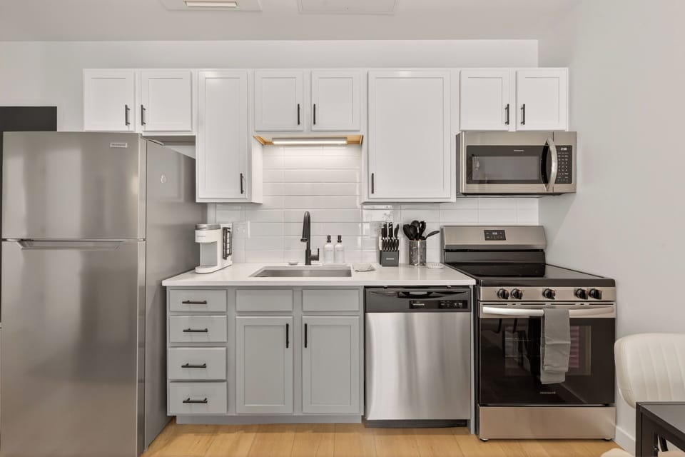 Sleek, fully stocked kitchen with stainless appliances and coffee essentials—style meets convenience.
