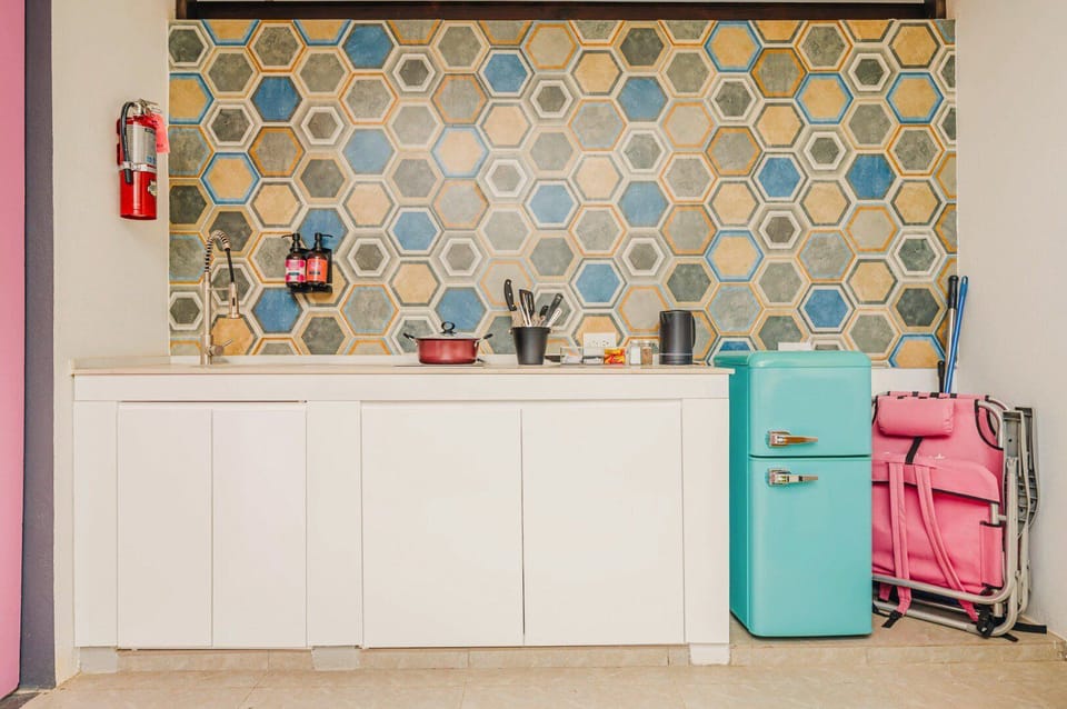 Kitchenette with retro fridge, stovetop, microwave, cookware, and so much more.