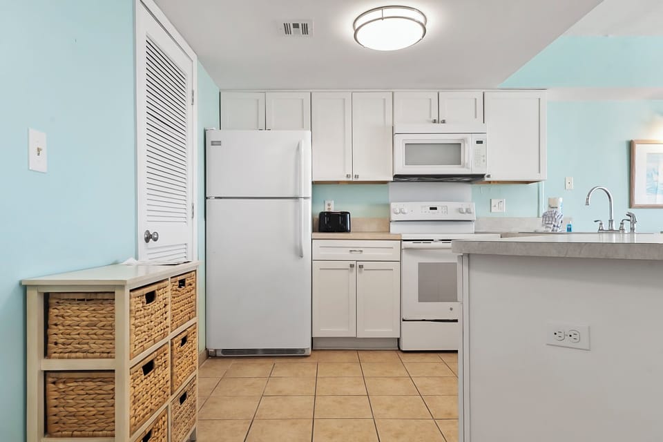 Fully-equipped kitchen with oven, stovetop, microwave, refrigerator, toaster, and more