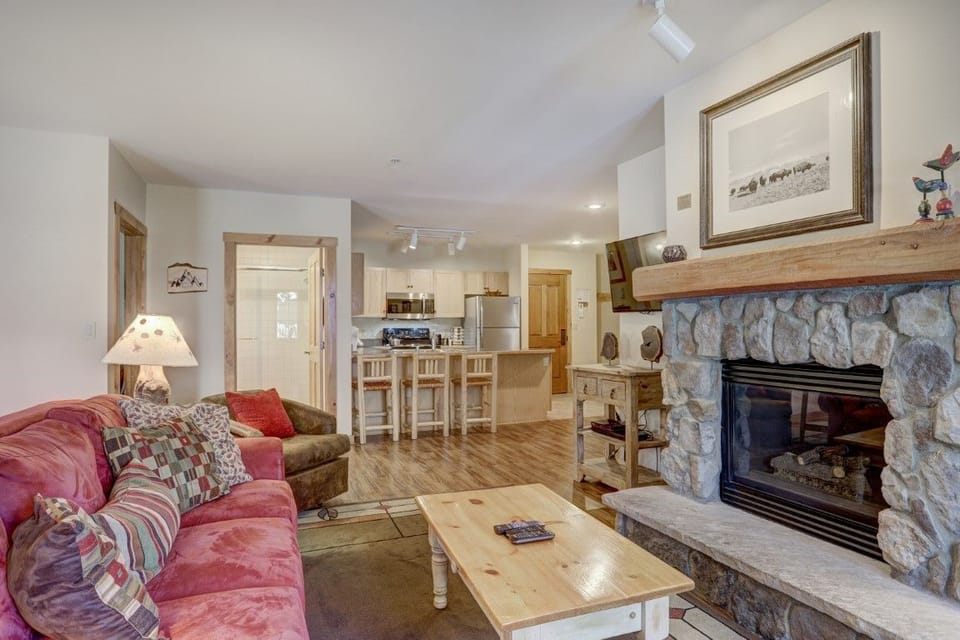 Step into the cozy living room featuring a warm fireplace and ample seating for relaxation.