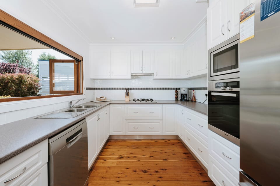 A fully equipped cooking space with a dishwasher, oven, stove, microwave, toaster, refrigerator, and all the essentials makes home-style meals effortless.