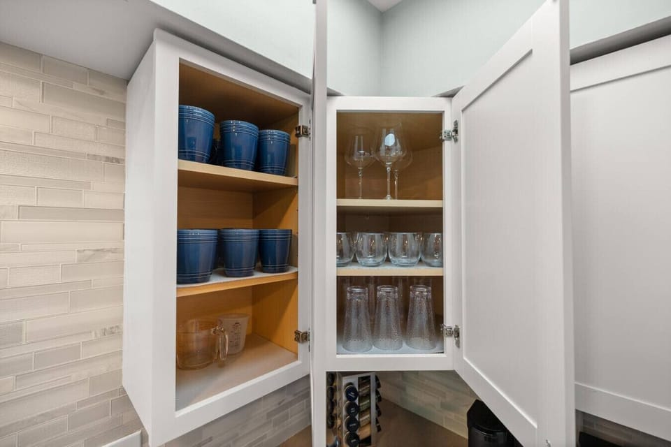 Stylish drinkware cabinets open to reveal a curated selection of beverage essentials.