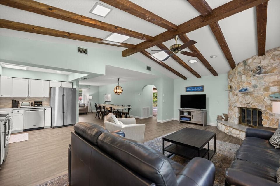 Vaulted ceilings with exposed beams in a massively wide open floor plan.