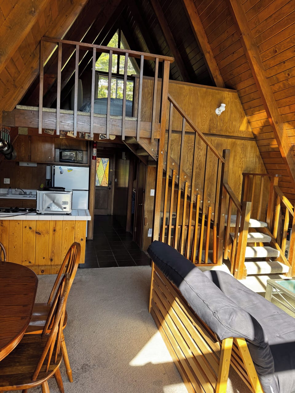 Open living area with loft railing visible & forest light — ideal for families o