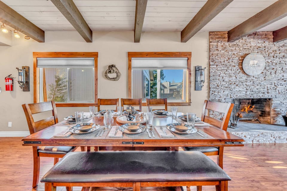 Dining Area: Large family table beside open kitchen with bar seating and bright windows